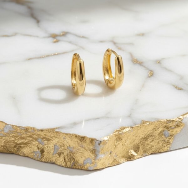 Model wearing DIVAART's stylish and lightweight gold oval hoop earrings, perfect for daily wear and complementing both Indian and Western outfits.
